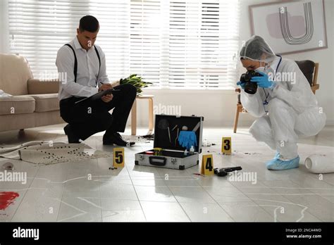 Investigators working at crime scene in living room Stock Photo - Alamy