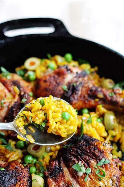 One pot chicken saffron rice with saffron, peas, olives and smoked paprika in a skillet with a ...