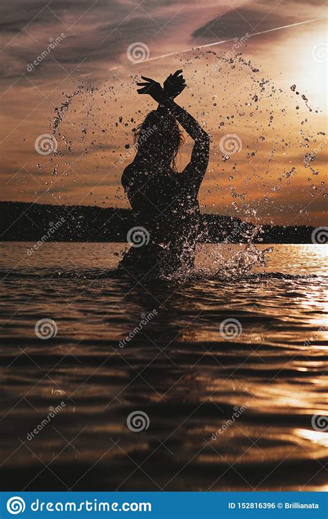 Young Model Swimming in the Sea - Sunset Time. Attractive Silhouette ...