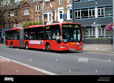 An articulated (bendy) bus passes through Ealing on its way to White City in West London. It is ...