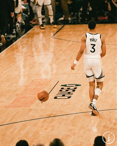 a basketball player dribbles the ball down the court while people watch ...