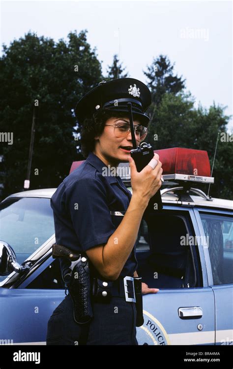 1970s POLICE WOMAN TALKS ON WALKIE TALKIE IN FROMT OF POLICE CAR Stock Photo - Alamy