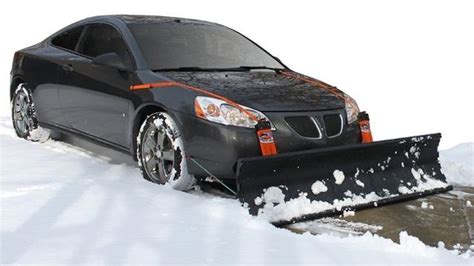 a car is parked in the snow with a snow plow attached to its front