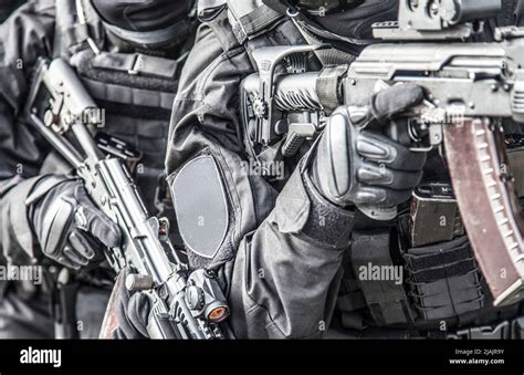 SWAT team members armed with service rifles, standing in stack formation during a suspect arrest ...