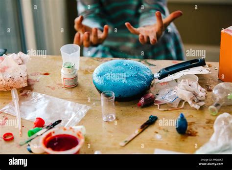 Hands of girl doing science experiment, blue liquid foaming in frying ...