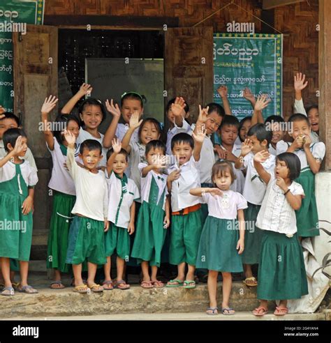 Group of young Myanmar schoolchildren in uniform waving and smiling ...