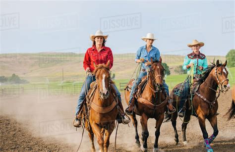 Cowgirls riding horses on ranch - Stock Photo - Dissolve