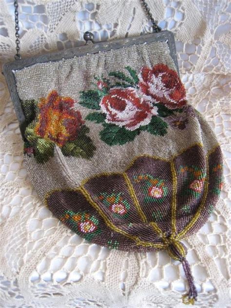 an old purse with flowers on it sitting on a lace doily covered tablecloth