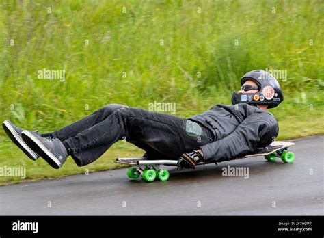 Rolling downhill laying on a skateboard known as buck boarding in the UK Stock Photo - Alamy