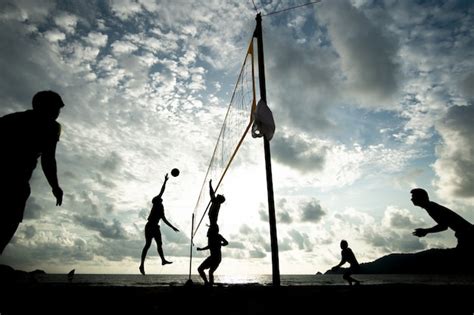 Premium Photo | Beach volleyball team playing during sunset time