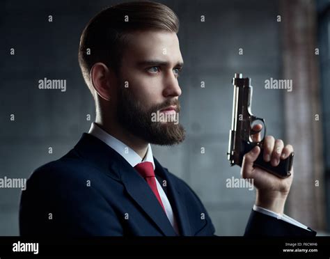 Young handsome man holding hand gun hi-res stock photography and images - Alamy