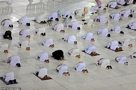 Worshippers observe social distancing as they pray in virtually empty Grand Mosque in Mecca ...