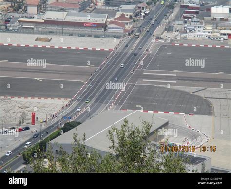 Gibraltar airport runway with the main road crossing Stock Photo - Alamy