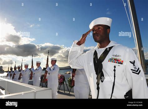 US Navy sailors salute during an ash scattering ceremony at the 73rd Anniversary commemoration ...