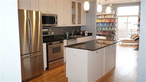 an open kitchen with stainless steel appliances and white cabinets ...