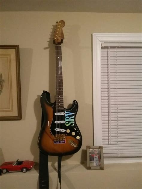 a guitar that is sitting on top of a shelf