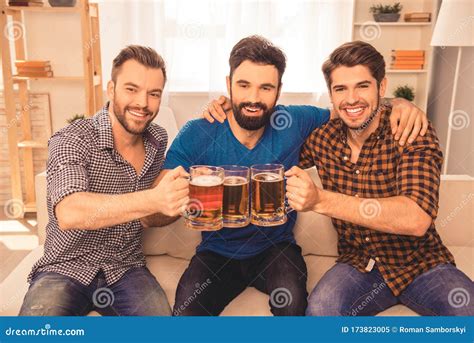 Cheers! Handsome Men Celebrating Victory and Clinking Glass of Beer at Home Stock Image - Image ...