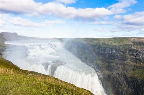 Premium Photo | Rainbow in water spray over gullfoss waterfall