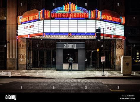 A nighttime exposure in front of an illuminated movie theater marquee Stock Photo - Alamy