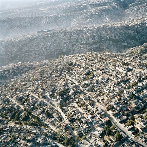 an aerial view of a city with mountains in the background