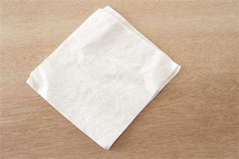 Plain white napkin on a wooden table - Free Stock Image