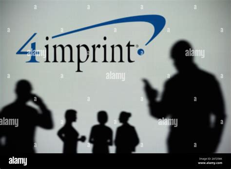 The 4Imprint logo is seen on an LED screen in the background while a silhouetted person uses a ...