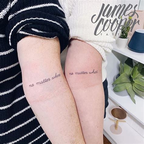 two people with tattoos on their arms and one is holding the other's arm