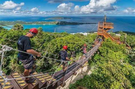 visitors crossing a wooden bridge as the get to a zip line in st thomas