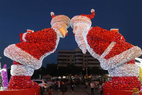 A model of Santa Claus bending forwards to kiss Mrs. Claus outside a shopping mall in Xuchang ...