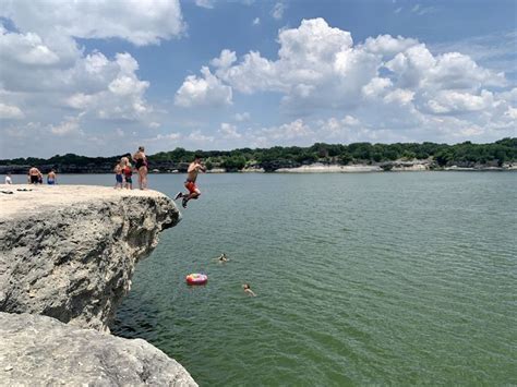 some people are jumping into the water from rocks