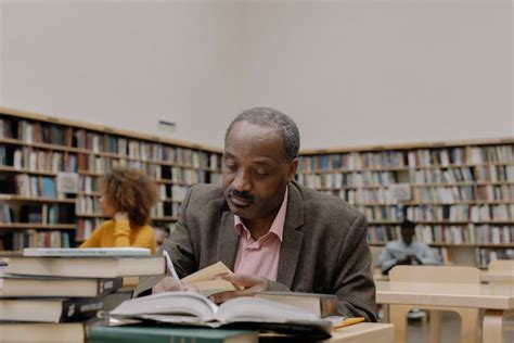 Man Sitting on Sofa Chair While Reading Book · Free Stock Photo