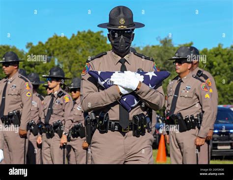 Florida Highway Patrol Captain James Edwards carries the American flag during the funeral ...