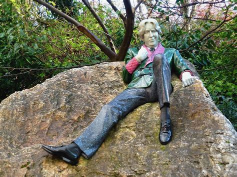 a statue of a man sitting on top of a rock