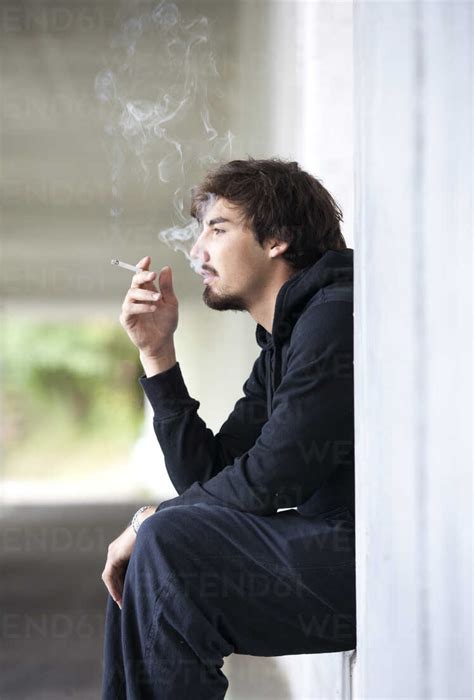 Young man smoking cigarette stock photo