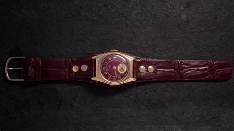 gold watch with a leather strap on Behance