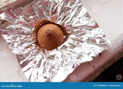 A Chocolate Truffle Candy Wrapped in a Foil Wrapper on an Old Wooden ...