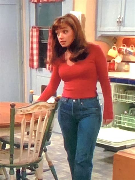 a woman standing next to a chair in a kitchen