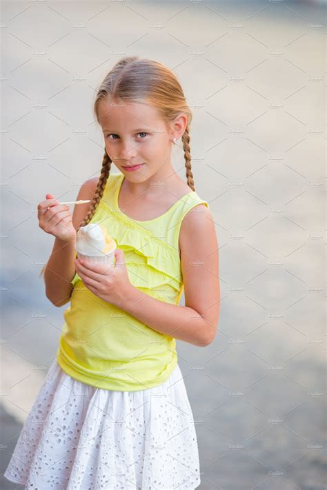 Adorable little girl eating icecream outdoors at summer cute kid enjoying | People Images ...