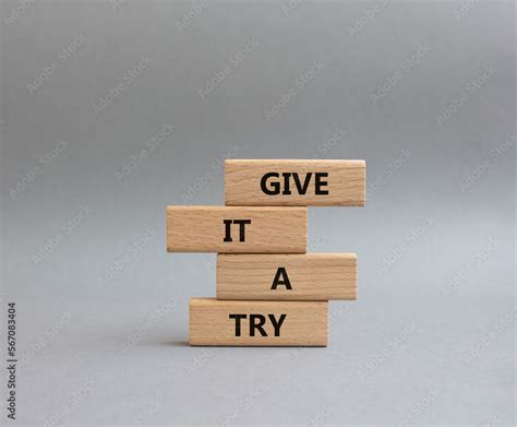 Give it a try symbol. Concept words Give it a try on wooden blocks. Beautiful grey background ...