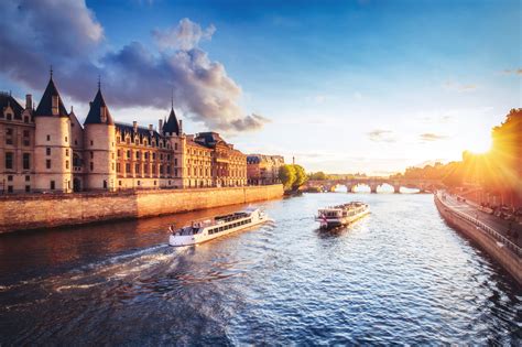 Dramatic sunset over river Seine in Paris, France, with Conciergerie and cruise boats. - Eye of ...