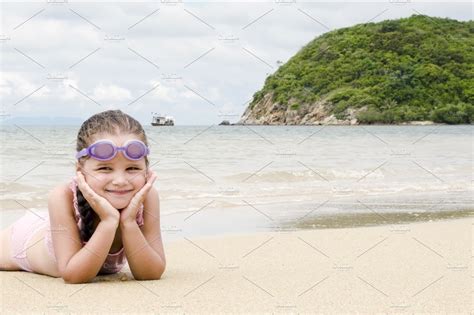 Happy little girl lying on the sand on the beach female preschooler kid stock | Holiday Stock ...