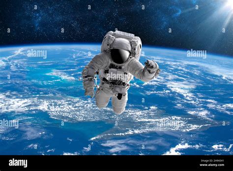 Astronaut in outer open space over the planet Earth.Stars provide the background.erforming a ...