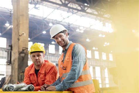 Portrait confident steel factory workers in factory — low angle view ...