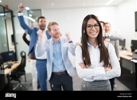 Happy business people celebrating success at company Stock Photo - Alamy