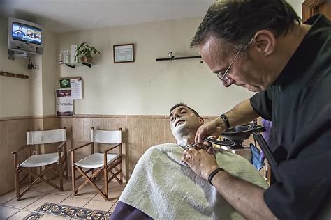 Barber Using A Straight Razor To Shave A Young Man In A Traditional Barbershop Sab Photo ...