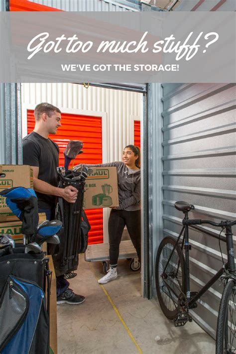 a man and woman standing in a storage room with bikes on the floor next to them