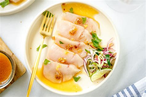 A round plate containing Hamachi Crudo dressed in a bright ponzu and ...