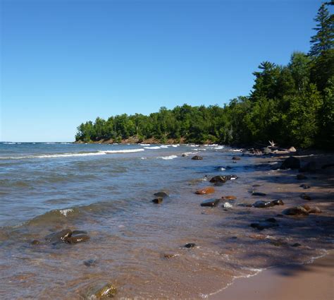 the beach is lined with rocks and trees