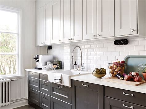 Black and white kitchen with white top cabinets and black bottom cabinets paired with white ...