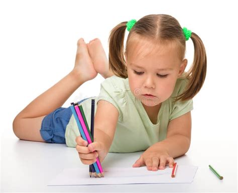 Little Girl Is Drawing While Laying On The Floor Stock Images - Image: 20239784